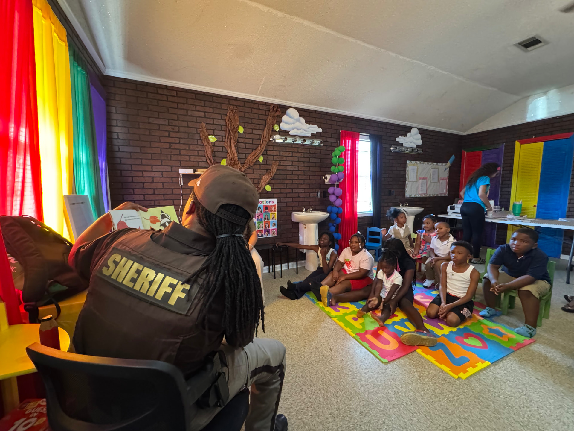 Community guest reading a story to children at Little Dreamers Academy